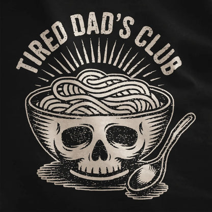 Bold ramen bowl with skull design and vintage "TIRED DAD'S CLUB" text on black shirt fabric, textured detail.