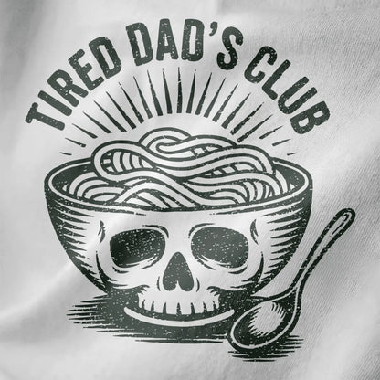 Distressed black and white ramen bowl with skull motif and "TIRED DAD'S CLUB" text on white fabric close-up.