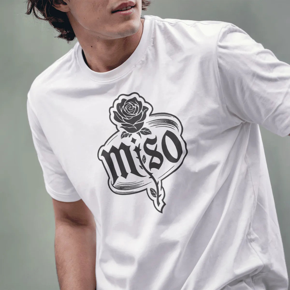 Male model wears white t-shirt with elegant rose and gothic miso text in distressed oval, line art style.