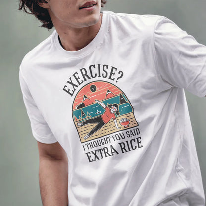 Male model in white t-shirt with humorous "EXERCISE? I THOUGHT YOU SAID EXTRA RICE" graphic and mountain background.