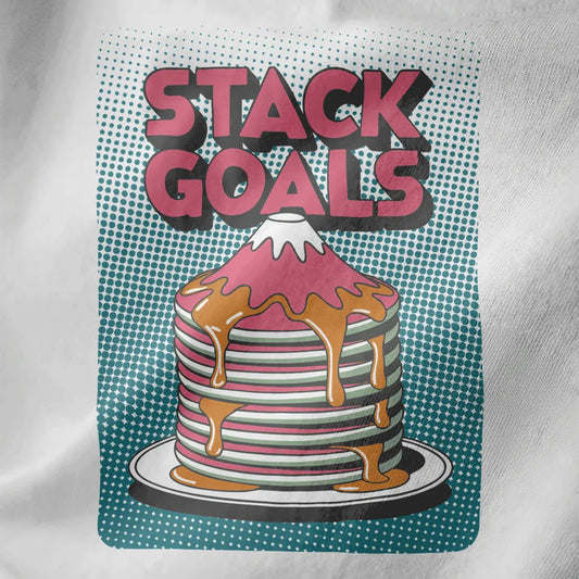 Close-up of pink and white pancake stack shaped like Mount Fuji with syrup and teal pop-art background on white fabric.