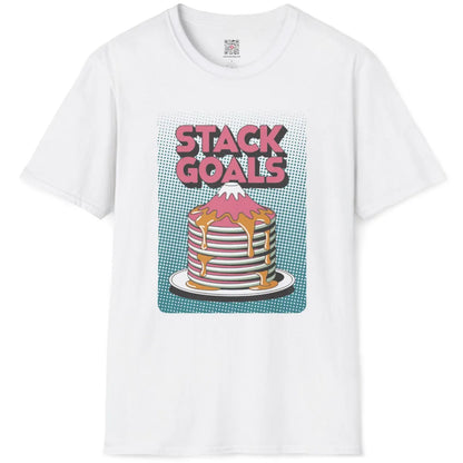 White flatlay tee with vibrant pastel pancake mountain and playful pink block "STACK GOALS" text on teal dots.