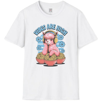 White flatlay tee featuring cartoonish pink alpaca with headphones, steaming ramen, and playful blue text arc.