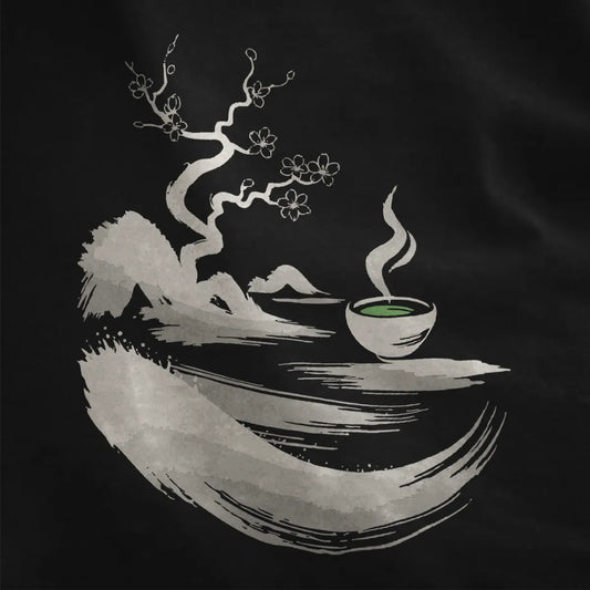 Black fabric close-up showing monochrome sumi-e twisted tree, cherry blossoms, and green matcha bowl.