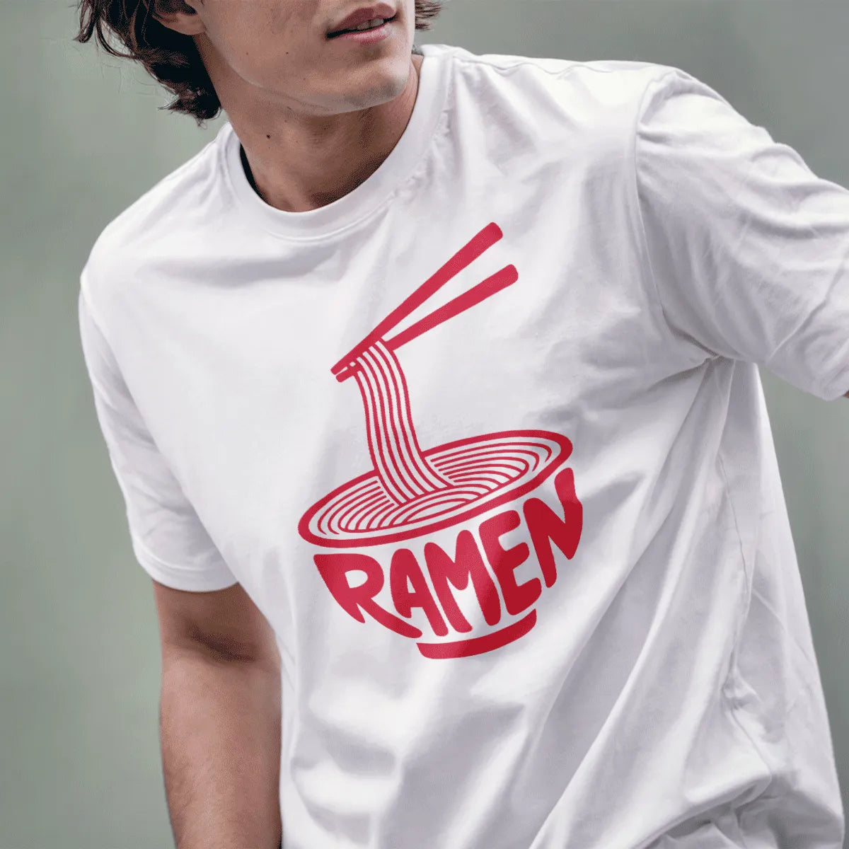 Male model wearing white t-shirt with red ramen bowl art and chopsticks holding noodles.