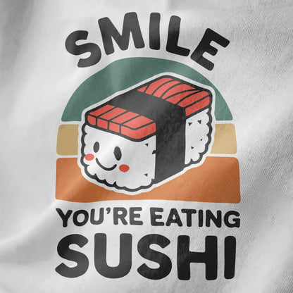 White fabric close-up of smiling nigiri sushi with rosy cheeks, bold "SMILE" text, sushi shirt, kawaii sushi.