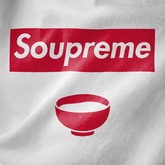 White t-shirt fabric close-up featuring bold Soupreme logo parody and red soup bowl, modern streetwear style.