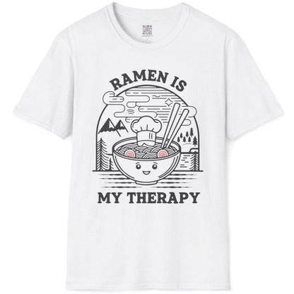 White t-shirt flatlay with anthropomorphic ramen bowl and serene mountain scene, cozy food, positive messaging.