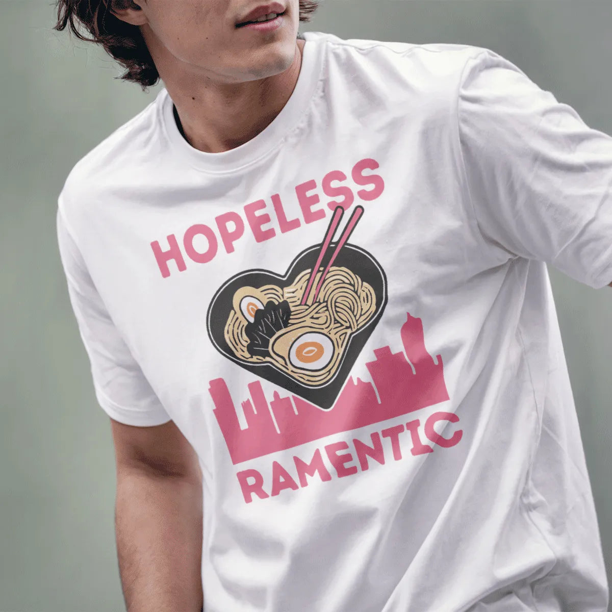 Male model in white t-shirt featuring heart ramen bowl, cityscape, and bold pink text, japanese t-shirts.