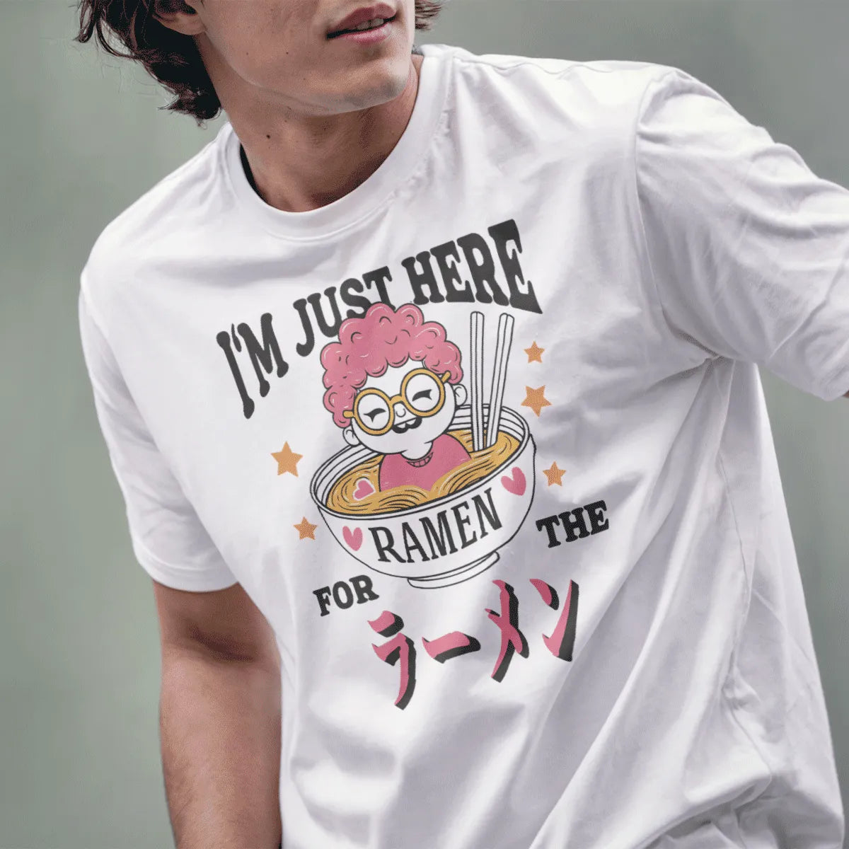 Male model wears white tee with pink-haired character peeking from ramen bowl, ramen joy, whimsical illustration.