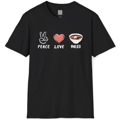 Black t-shirt flatlay with vibrant peace sign, heart, and detailed miso soup bowl artwork in cultural fusion style.