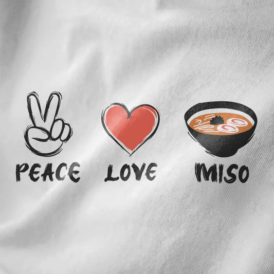 White fabric close-up showing dynamic peace sign, heart, and steaming miso soup bowl with hand-drawn text.