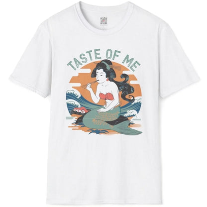 White t-shirt flatlay with mermaid eating sushi, set against serene landscape and dynamic waves.