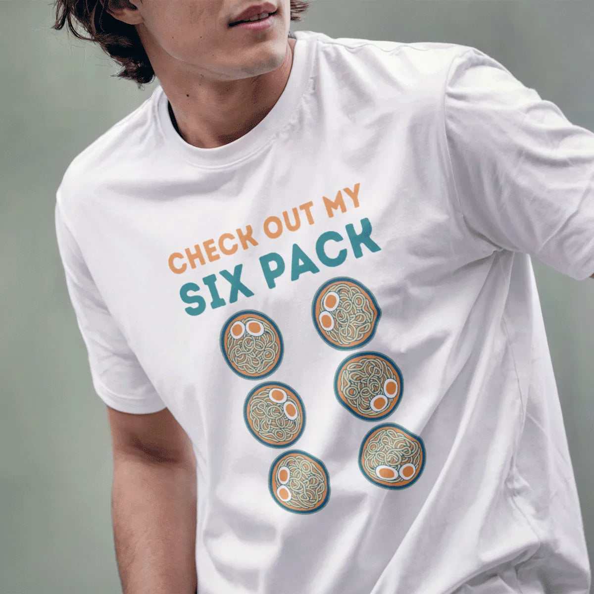 Male model in white t-shirt with six ramen bowls, bold teal text; ramen t-shirt, humorous quote.